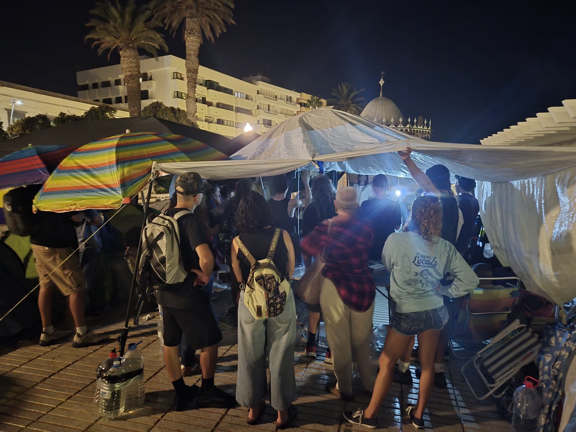 La carpa de noche con gente charlando